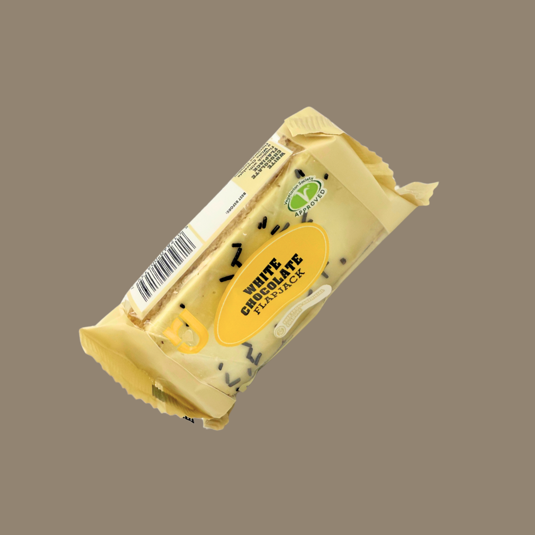 White Chocolate Flapjack next to fruit and coffee as breakfast snack