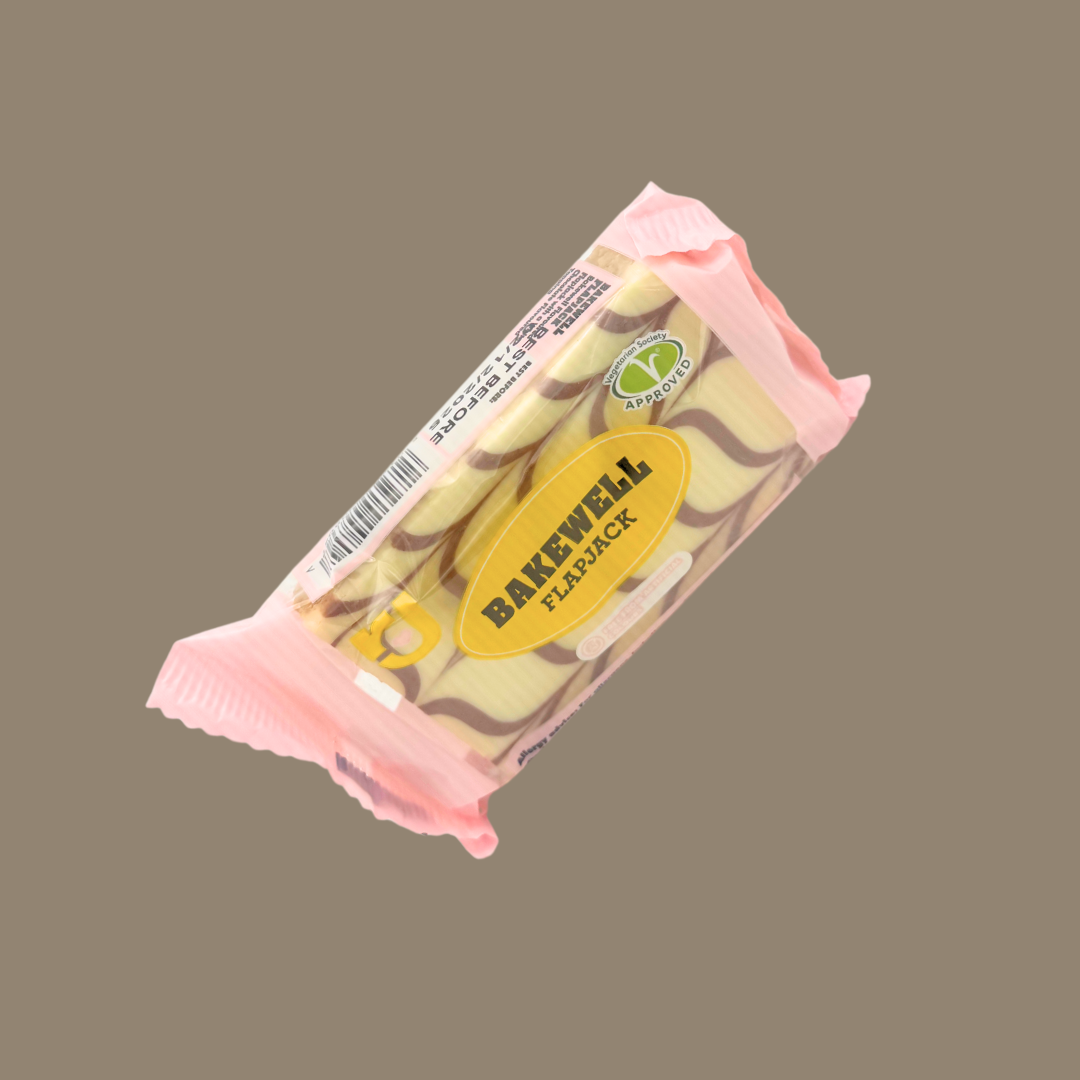 Hand holding a Bakewell flapjack in a picnic setting
