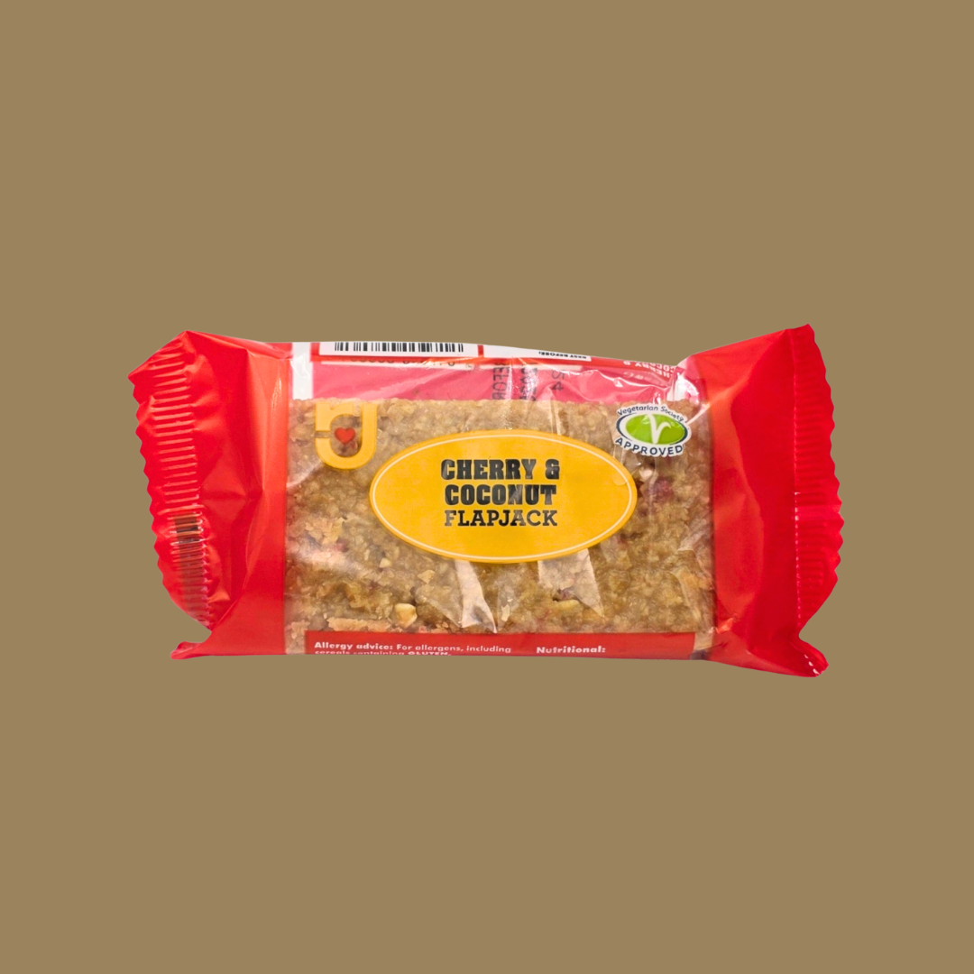 Row of 24 RJ Cherry & Coconut flapjacks neatly arranged on a wooden board