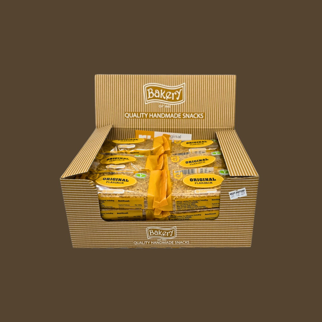 Flapjack bar beside a bowl of oats and a glass of milk for breakfast