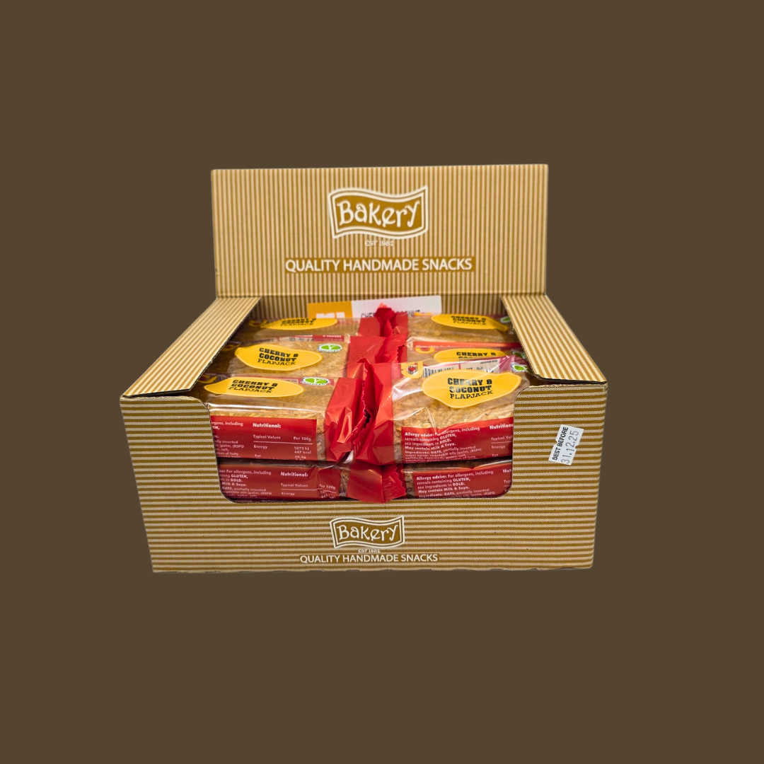 Cherry & Coconut flapjack beside a bowl of shredded coconut and fresh cherries