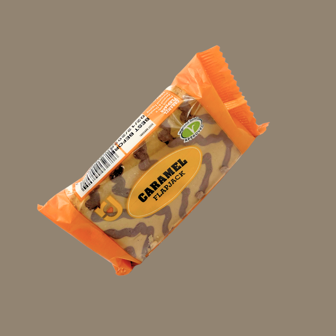 Stack of 24 RJ Caramel Flapjacks multipack next to coffee and fruit