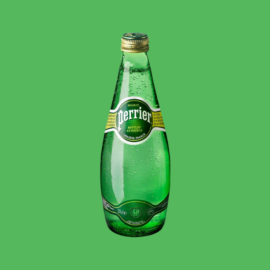 Hand holding a chilled Perrier bottle beside a plate of fresh fruit