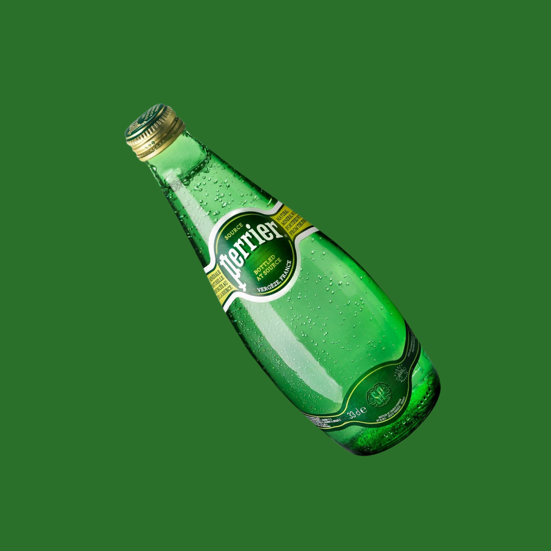 Single Perrier glass bottle with condensation droplets visible