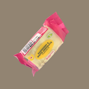 Hand holding a raspberry & white chocolate flapjack over a gym towel