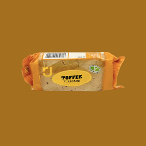 Row of 24 individually wrapped toffee flapjacks neatly arranged on countertop
