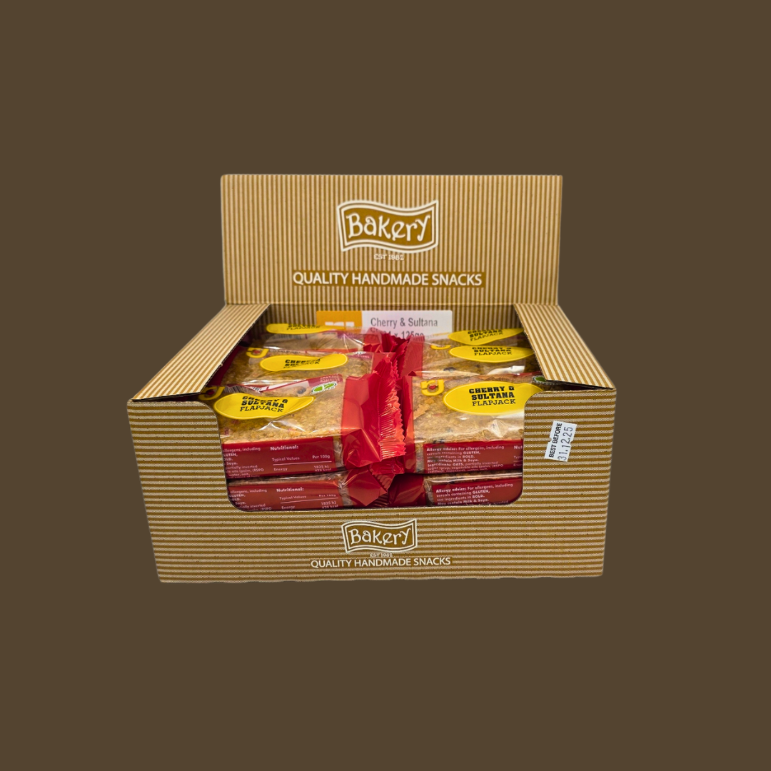 Row of 24 individually wrapped Cherry & Sultana flapjacks on a wooden board
