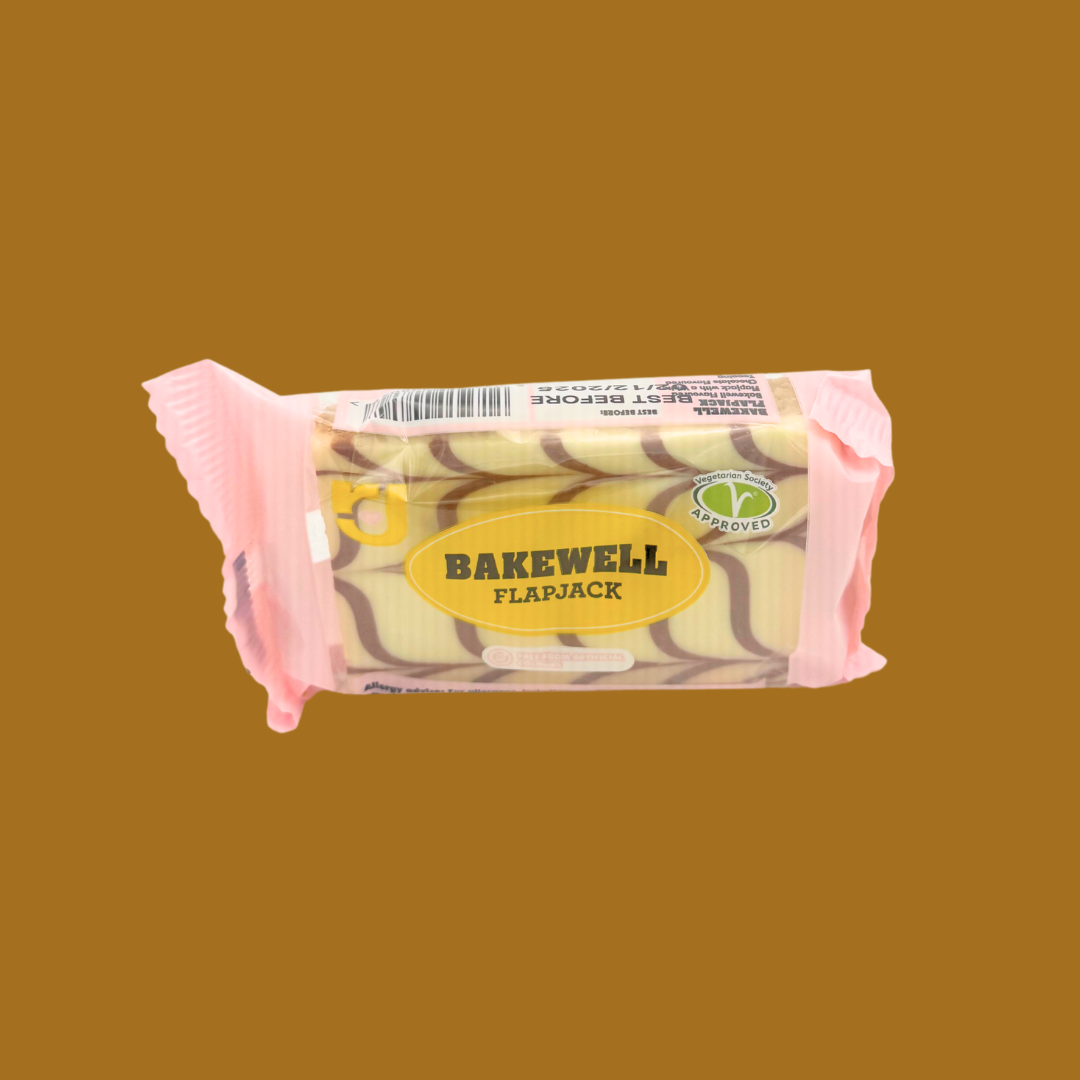 Row of 24 individually wrapped Bakewell flapjacks on wooden surface