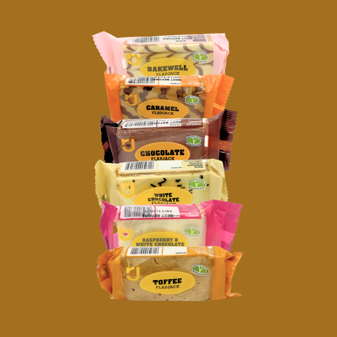 Close-up of an unwrapped raspberry flapjack bar showing oat fibre and fruit pieces