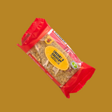 Hand holding a Cherry & Coconut flapjack bar over a beach towel

