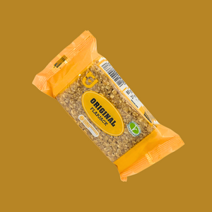 Hand holding one flapjack bar with mixed-flavor pack in the background
