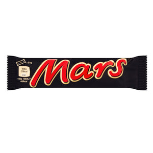 Hand holding a Mars Bar with a stack of bars in the background

