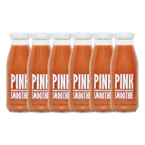 A bottle of Pressuice Pink Smoothie alongside fresh strawberries, raspberries, and bananas.